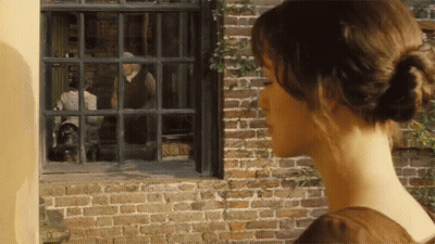 A Woman Looks Out Of A Window At A Man In A Suit GIF