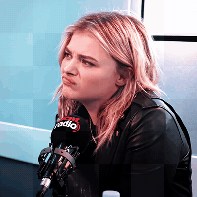 A Woman Making A Face Behind A Microphone That Says Fox Radio GIF