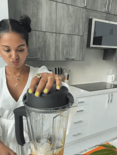 A Woman Making A Face While Holding A Blender GIF