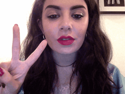 A Woman Making A Peace Sign With Her Hand GIF
