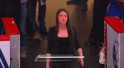 A Woman Named Briannah Donolo Is Smiling While Standing In A Hallway GIF