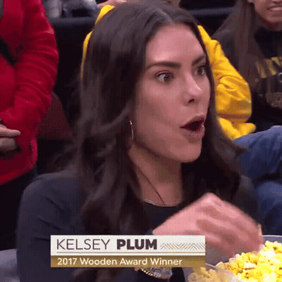 A Woman Named Kelsey Plum Is Eating Popcorn At A Game GIF