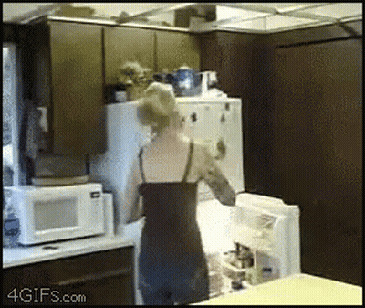 A Woman Opens A Refrigerator Door In A Kitchen With A 4Gifs.com Watermark GIF