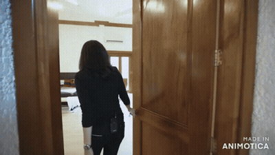 A Woman Opens A Wooden Door With The Words Made In Animatica On The Bottom GIF