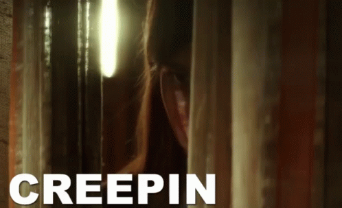 A Woman Peeking Out From Behind A Curtain With Creepin Written In White GIF