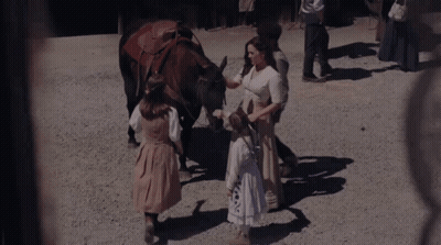 A Woman Petting A Horse While A Little Girl Stands Next To It GIF