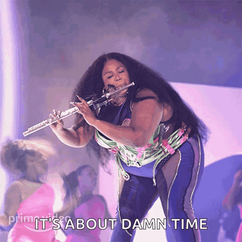 A Woman Playing A Flute With The Words " It 'S About Damn Time " Below Her GIF