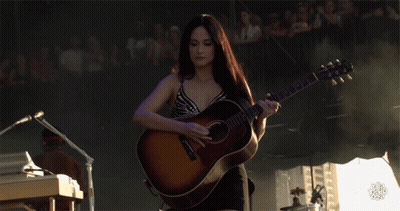 A Woman Playing A Guitar With A Yamaha Logo On It GIF