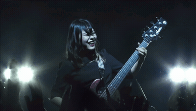 A Woman Playing A Guitar With A Yamaha Logo On The Headstock GIF