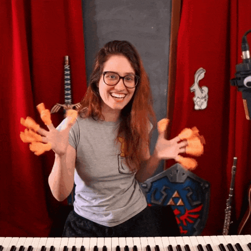 A Woman Playing A Keyboard With A Sword And Shield In The Background GIF