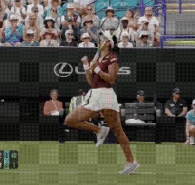 A Woman Playing Tennis In Front Of A Lexus Sign GIF
