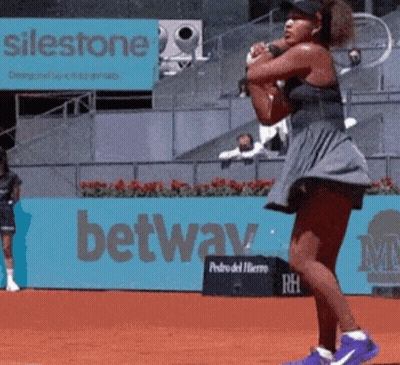 A Woman Playing Tennis In Front Of A Sign That Says ' Silestone ' On It GIF