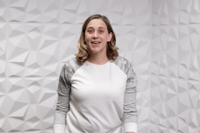 A Woman Pointing At The Camera With The Words " You Rock " Behind Her GIF