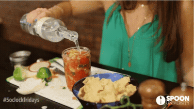 A Woman Pouring A Drink Into A Glass With Spoon University Written On The Bottom GIF