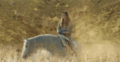 A Woman Riding A Horse In A Field GIF