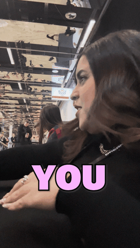 A Woman 'S Face Is Behind A Pink Sign That Says " You " GIF