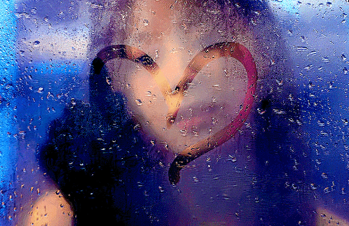 A Woman 'S Face Is Behind A Window With A Heart Drawn On It GIF