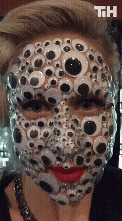 A Woman 'S Face Is Covered In Googly Eyes With The Letters Th On The Bottom GIF