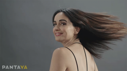 A Woman 'S Hair Is Blowing In The Wind In Front Of A Pantaya Ad GIF