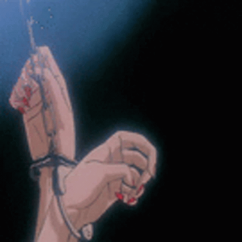 A Woman 'S Hands Are Tied To A Chain In A Dark Room . GIF