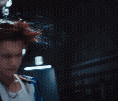 A Woman 'S Head Is Being Sprayed With Water In The Dark GIF