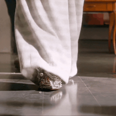 A Woman 'S Legs Are Shown In A Close Up Of A White Fur Coat GIF