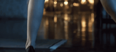 A Woman 'S Legs Are Shown In Front Of A Blurry Background Of Lights GIF