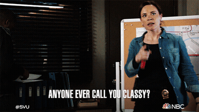 A Woman Says " Anyone Ever Call You Classy " While Standing In Front Of A Board GIF