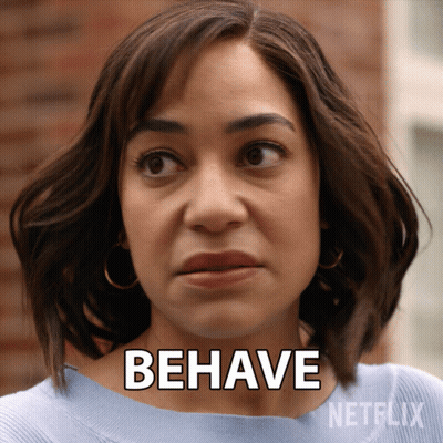 A Woman Says " Behave " In Front Of A Netflix Advertisement GIF