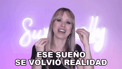 A Woman Says " Ese Sueno Se Volvio Realidad " In Front Of A Neon Sign GIF