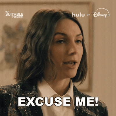 A Woman Says " Excuse Me " In Front Of A Hulu Logo GIF