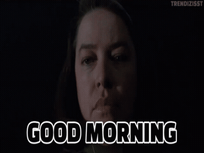 A Woman Says Good Morning In Front Of A Dark Background GIF