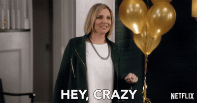 A Woman Says Hey Crazy In Front Of A Bunch Of Balloons GIF