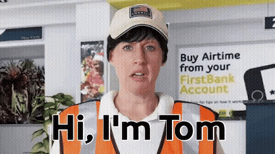 A Woman Says Hi I 'M Tom In Front Of A Sign That Says Buy Airtime From Your First Bank Account GIF