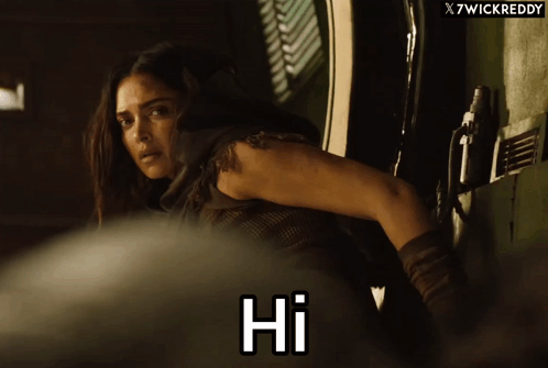 A Woman Says Hi In Front Of A X7wickreddy Banner GIF