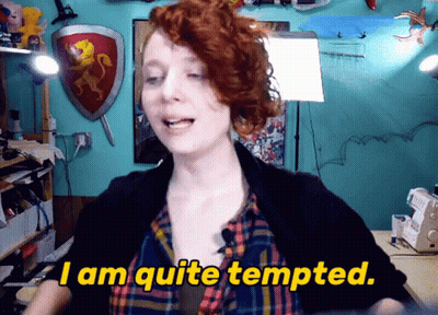 A Woman Says " I Am Quite Tempted " In Front Of A Blue Wall GIF