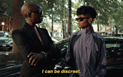 A Woman Says I Can Be Discreet While Standing Next To Another Woman In Front Of A Car GIF