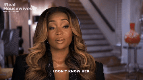 A Woman Says " I Don 'T Know Her " In Front Of A Real Housewives Logo GIF