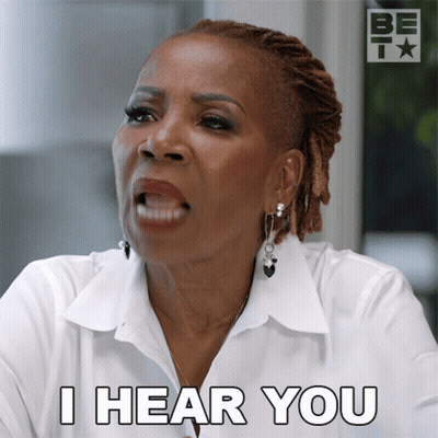 A Woman Says " I Hear You " In A White Shirt GIF