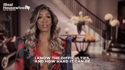 A Woman Says " I Know The Difficulties And How Hard It Can Be " In Front Of A Sign That Says Real Housewives GIF