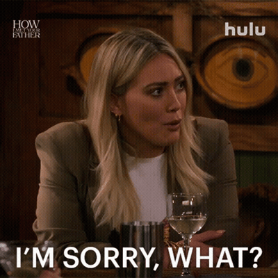 A Woman Says I 'M Sorry What While Holding A Glass Of Wine GIF