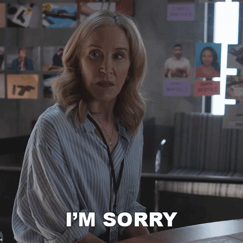A Woman Says I 'M Sorry While Standing In Front Of A Desk GIF