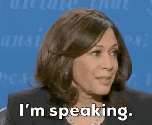 A Woman Says I 'M Speaking In Front Of A Blue Wall GIF