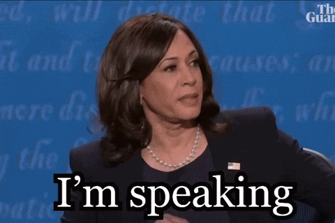 A Woman Says I 'M Speaking While Sitting At A Table GIF