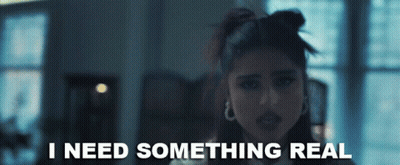 A Woman Says I Need Something Real In A Dark Room GIF