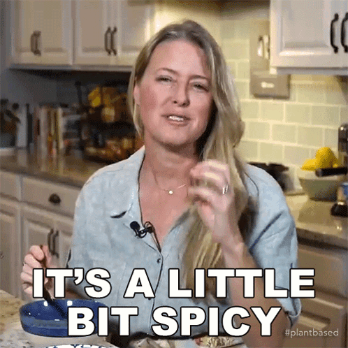 A Woman Says It 'S A Little Bit Spicy While Eating Food GIF