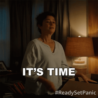 A Woman Says It 'S Time While Standing Next To A Lamp GIF