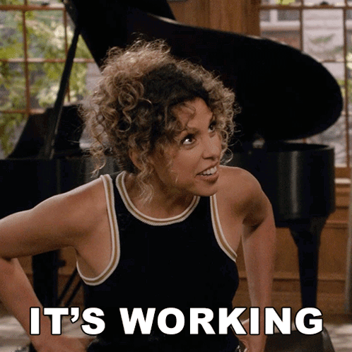 A Woman Says It 'S Working While Standing In Front Of A Piano GIF