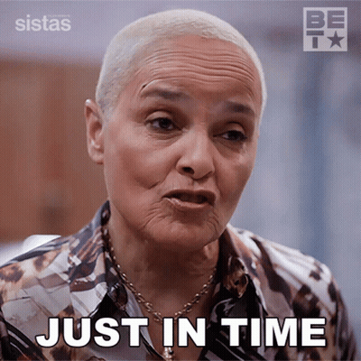 A Woman Says Just In Time While Wearing A Shirt And Necklace GIF
