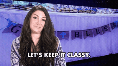 A Woman Says Let 'S Keep It Classy In Front Of A Table With Banners That Say Bless GIF